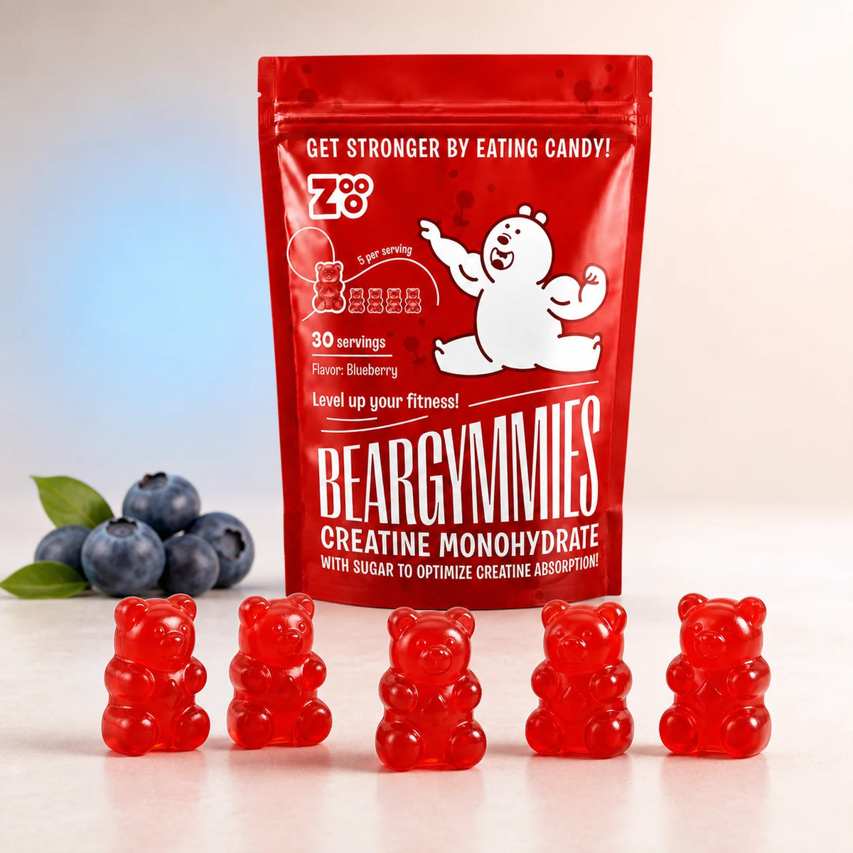 Close-up van vijf Beargymmies Blueberry creatine gummies met de verpakking en blauwe bessen